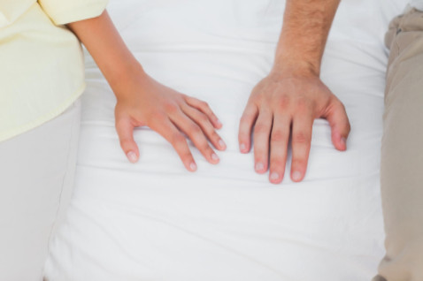 hands of couple in bed: SBD Medical Women’s Issues blog